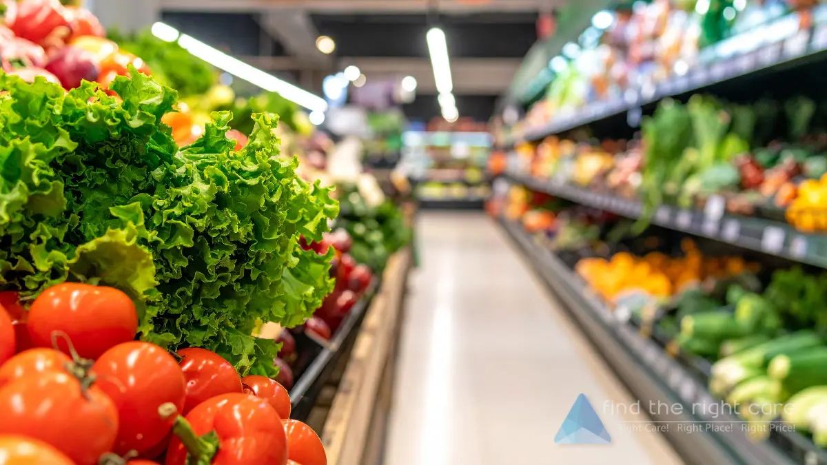 Close-up of fresh red tomatoes and green lettuce in a brightly lit grocery store produce aisle, with the "find the right care" logo in the bottom right corner.